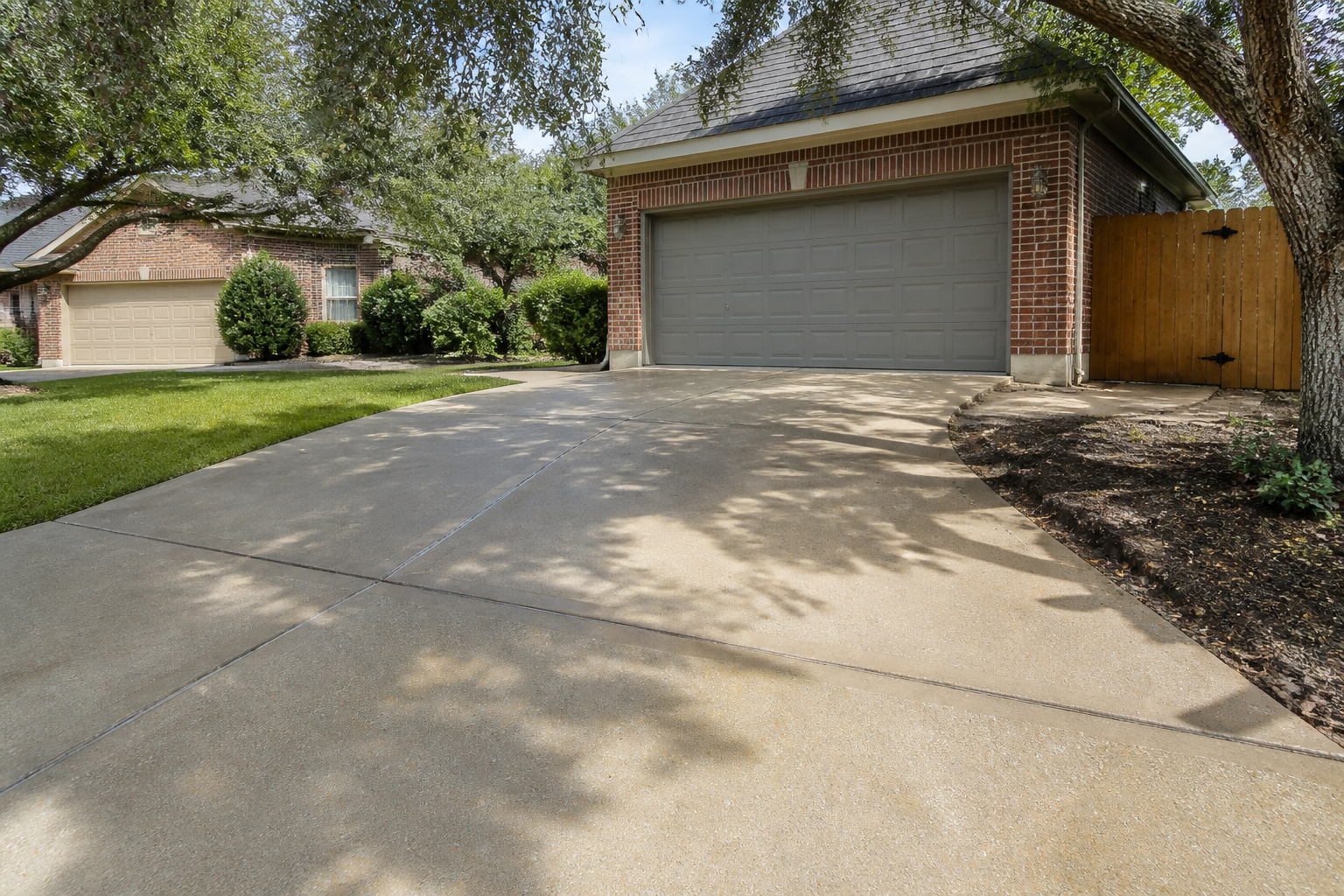 A clean concrete driveway in San Antonio after being pressure washed, showing the importance of proper home exterior maintenance.